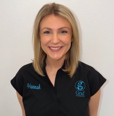 Hannah, Clinical Assistant at Graf Orthodontics, smiling in a black uniform with the Graf logo and her name embroidered, showcasing the friendly team environment in Northwest Louisiana.