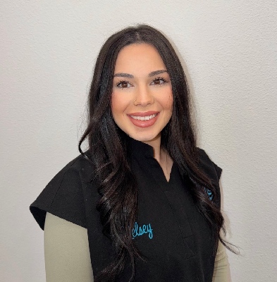 Kelsey, Clinical Assistant at Graf Orthodontics, smiling in a black uniform with her name embroidered, showcasing a welcoming demeanor for patient care in Northwest Louisiana.