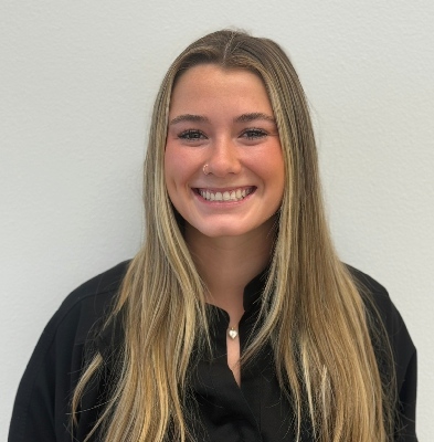 Joanie, smiling clinical assistant at Graf Orthodontics, wearing a black shirt against a neutral background.